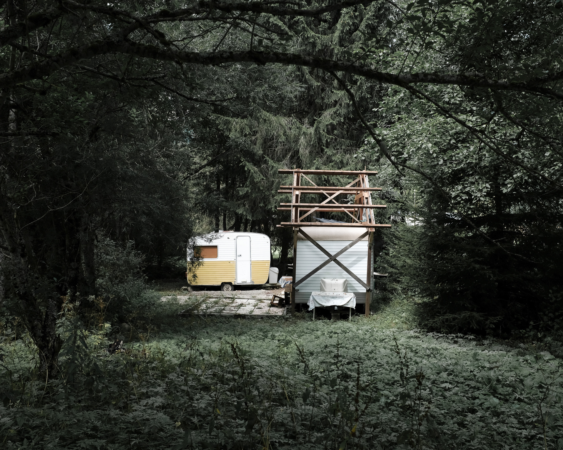 Photo à la montagne d'une caravane, un lieu de vie niché au milieu des arbres par Aurélien Delafond