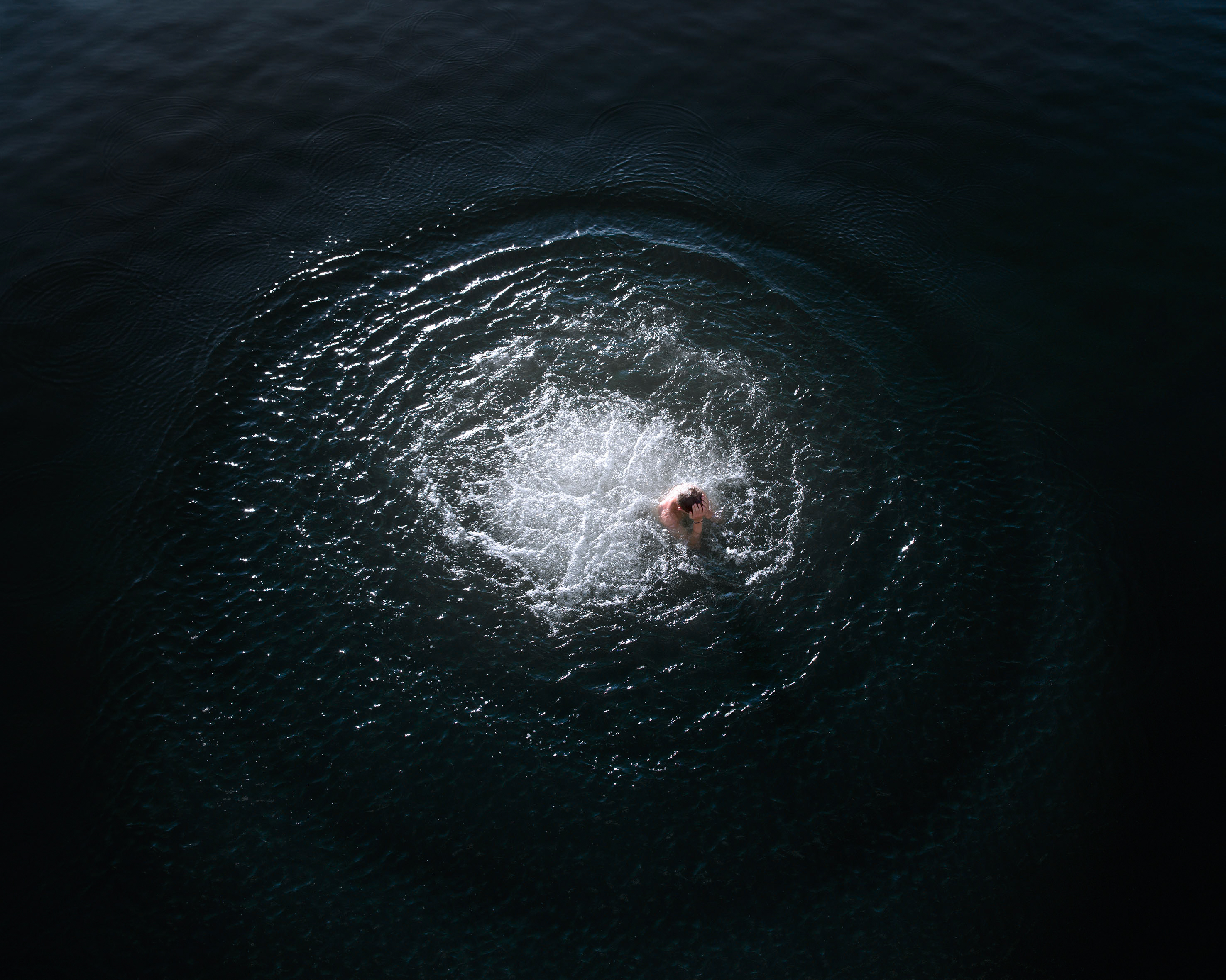 Photographie en Bretagne d'un homme en plein milieu de l'eau après avoir sauté par Richard Baron