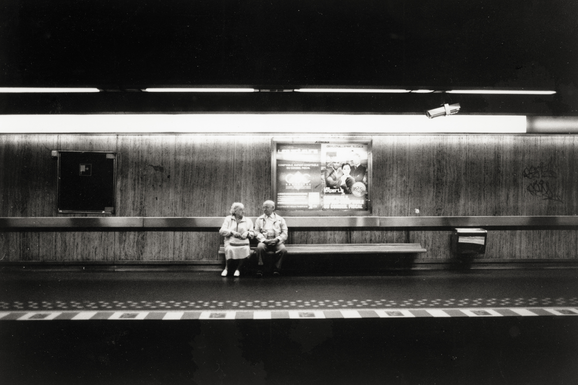 Image d'un couple assis le long du quai du métro dans cet espace souterrain public Mathieu Dréan