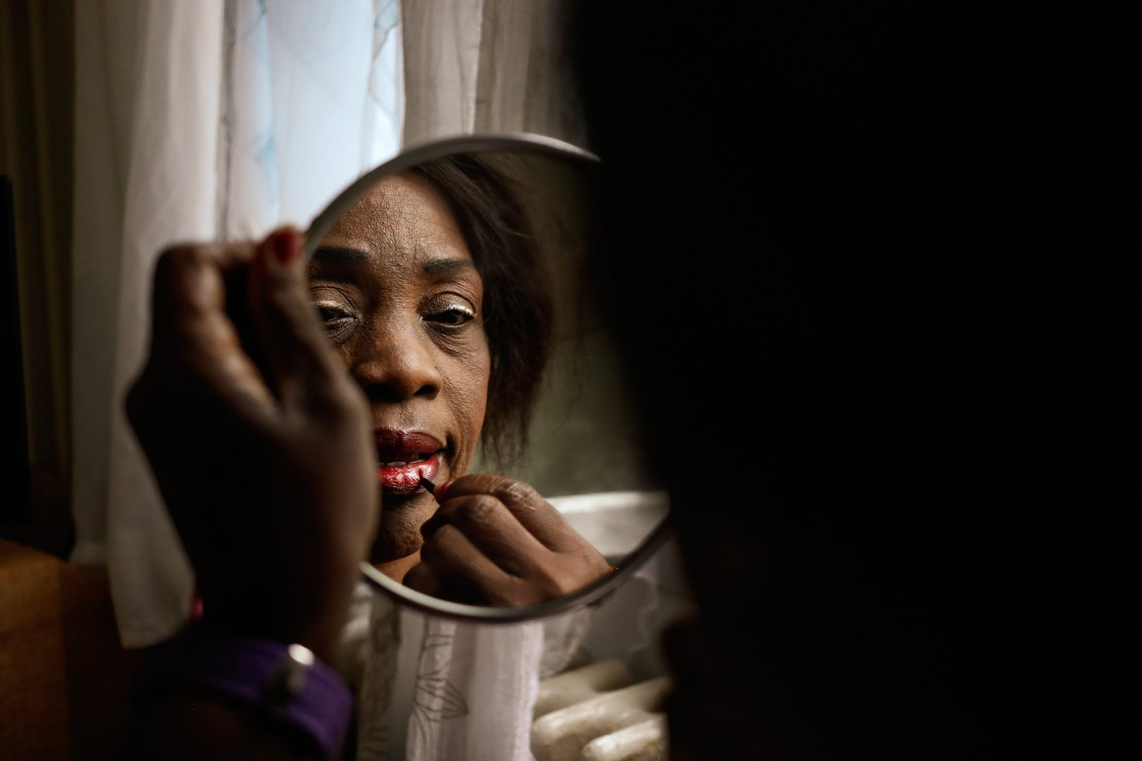 Photo d'une femme reflétant dans le miroir qui se maquille par la photographe Anouk Desury