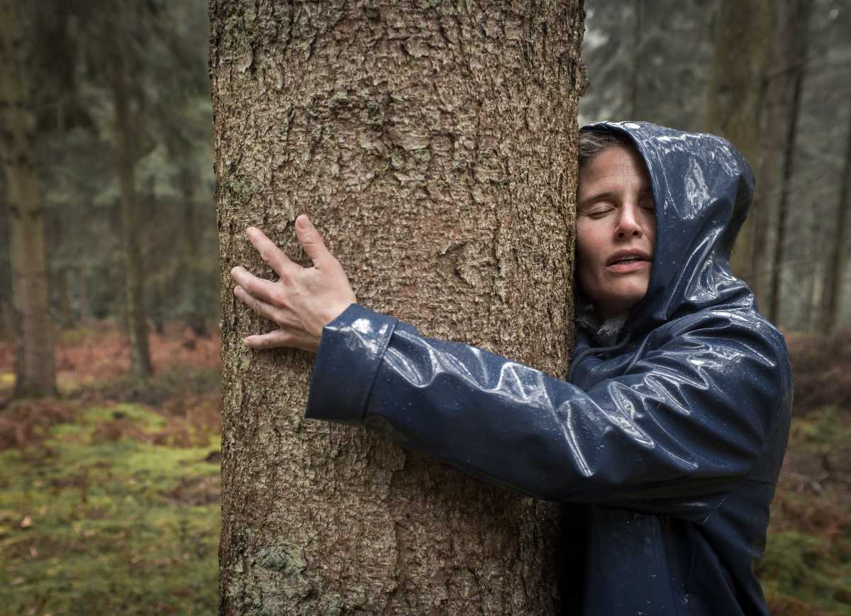 Image paysage naturel d'une femme enlaçant un arbre une pratique de la sylvothérapie