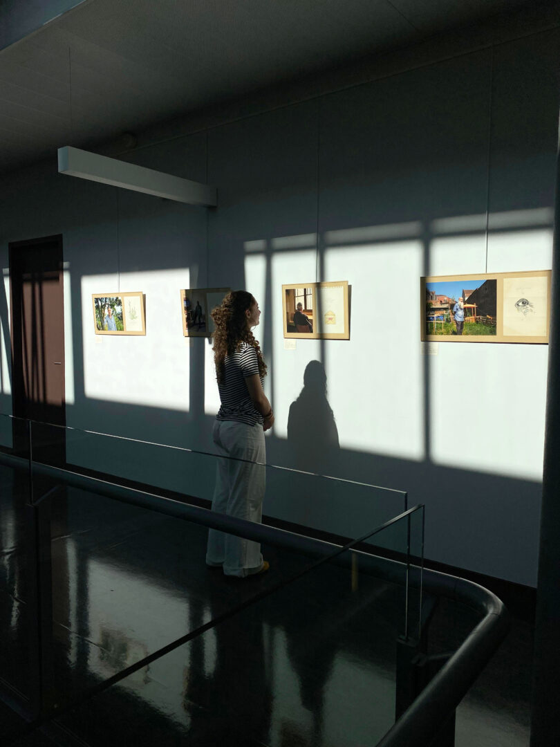 Visuel montrant du public à l'exposition "Les Cheveux Blancs" d'Anouk Desury, lors de son exposition à l'Ecole Nationale de protection judiciaire de la jeunesse (ENPJJ) du 19 septembre au 17 octobre 2025, à l'occasion des Journées du Patrimoine 2025. Cette exposition est un hommage aux travailleurs et travailleuses immigré.e.s du Nord et à leurs familles (venant d’Algérie, du Maroc, de unisie, de Pologne, du Sénégal, de Mauritanie, d’Espagne et autres).