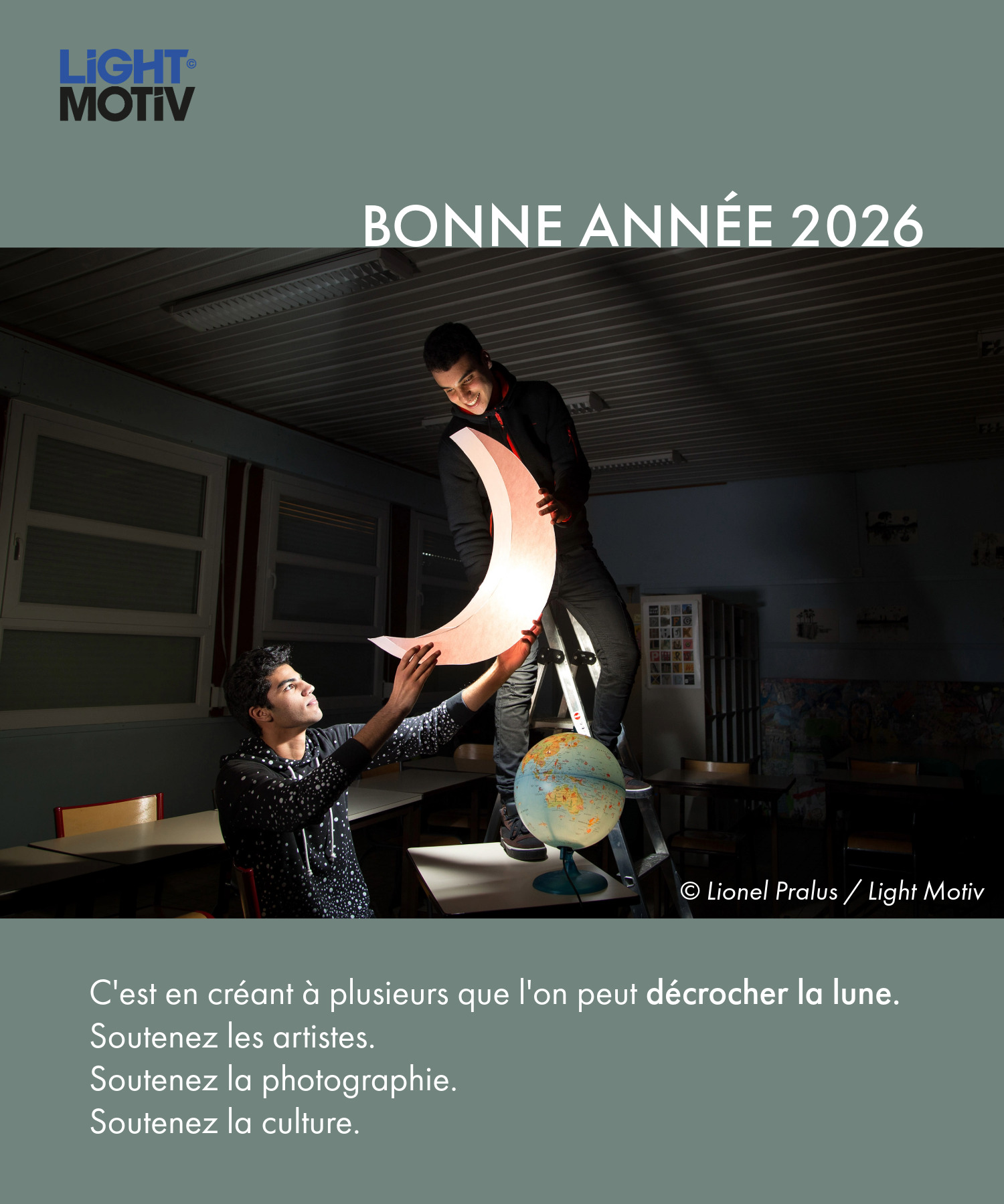 Visuel de voeux de la nouvelle année 2026 par l'agence photographique Light Motiv, avec une photographie issue de la série de Lionel Pralus représentant deux jeunes hommes décrochant un croissant de lune illuminé dans une salle de classe. Un texte est ajouté sous l'image : "C'est en créant à plusieurs que l'on peut décrocher la lune. Soutenez les artistes. Soutenez la photographie. Soutenez la culture."
