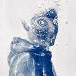 Photographie de Lionel Pralus / Light Motiv, issue de la série intitulée Blackholes, représentant un plan poitrine d'un jeune homme tourné vers la droite de l'image en négatif (cyanotype) de couleurs bleu et blanc avec des effets visuels apportés grâce à la technique du cyanotype, son regard est tourné vers la caméra, dans le cadre d'un projet porté sur les handicaps invisibles chez les jeunes.