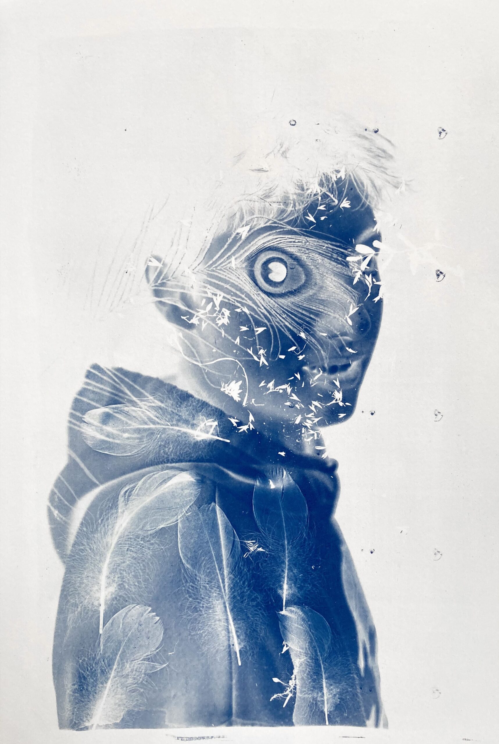 Photographie de Lionel Pralus / Light Motiv, issue de la série intitulée Blackholes, représentant un plan poitrine d'un jeune homme tourné vers la droite de l'image en négatif (cyanotype) de couleurs bleu et blanc avec des effets visuels apportés grâce à la technique du cyanotype, son regard est tourné vers la caméra, dans le cadre d'un projet porté sur les handicaps invisibles chez les jeunes.